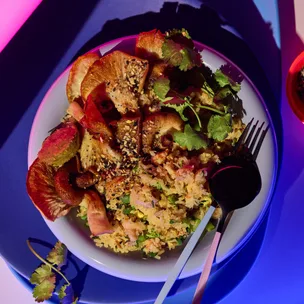 Spanner crab and mushroom fried rice in a bowl with neon-lit background