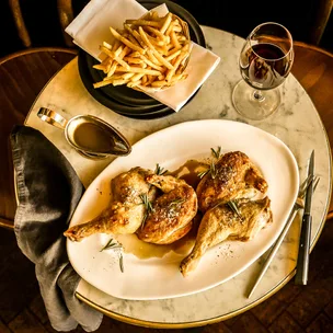 France-Soir's roast halved chicken with a side of jus and potato frites