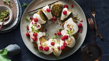 new christmas recipe image depicting a christmas cake with white frosting and raspberries in the shape of a wreath