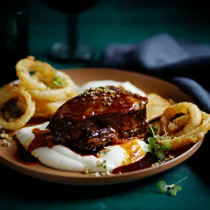Pilsener-braised beef short ribs with cauliflower mash and onion rings