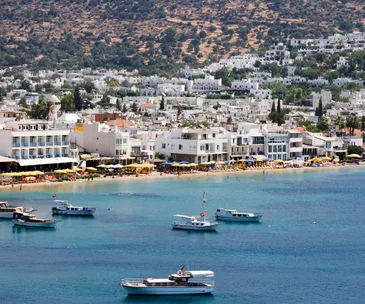 Coastal city of Bodrum in Türkiye (Turkey) depicting the ocean, boats and Bodrum buildings. 