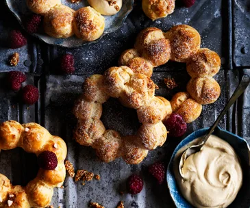 Choux wreaths with burnt-honey cream, raspberries and sesame praline